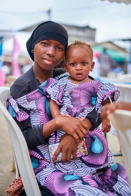 a woman sitting next to her child on a chair