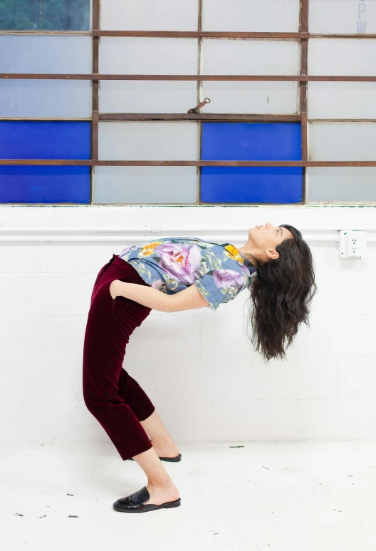 a woman standing with her head hanging over the side of a wall