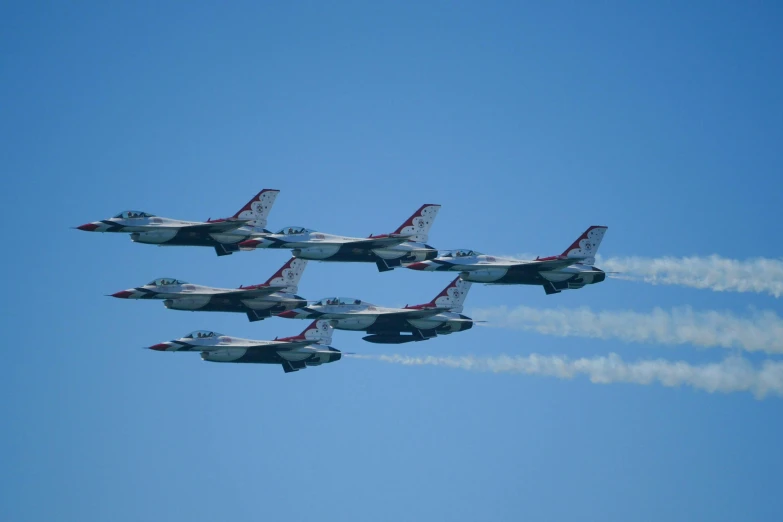 four fighter jets flying in formation against a blue sky