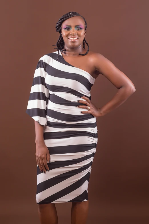 a woman with her arms on her hips standing in front of a brown background