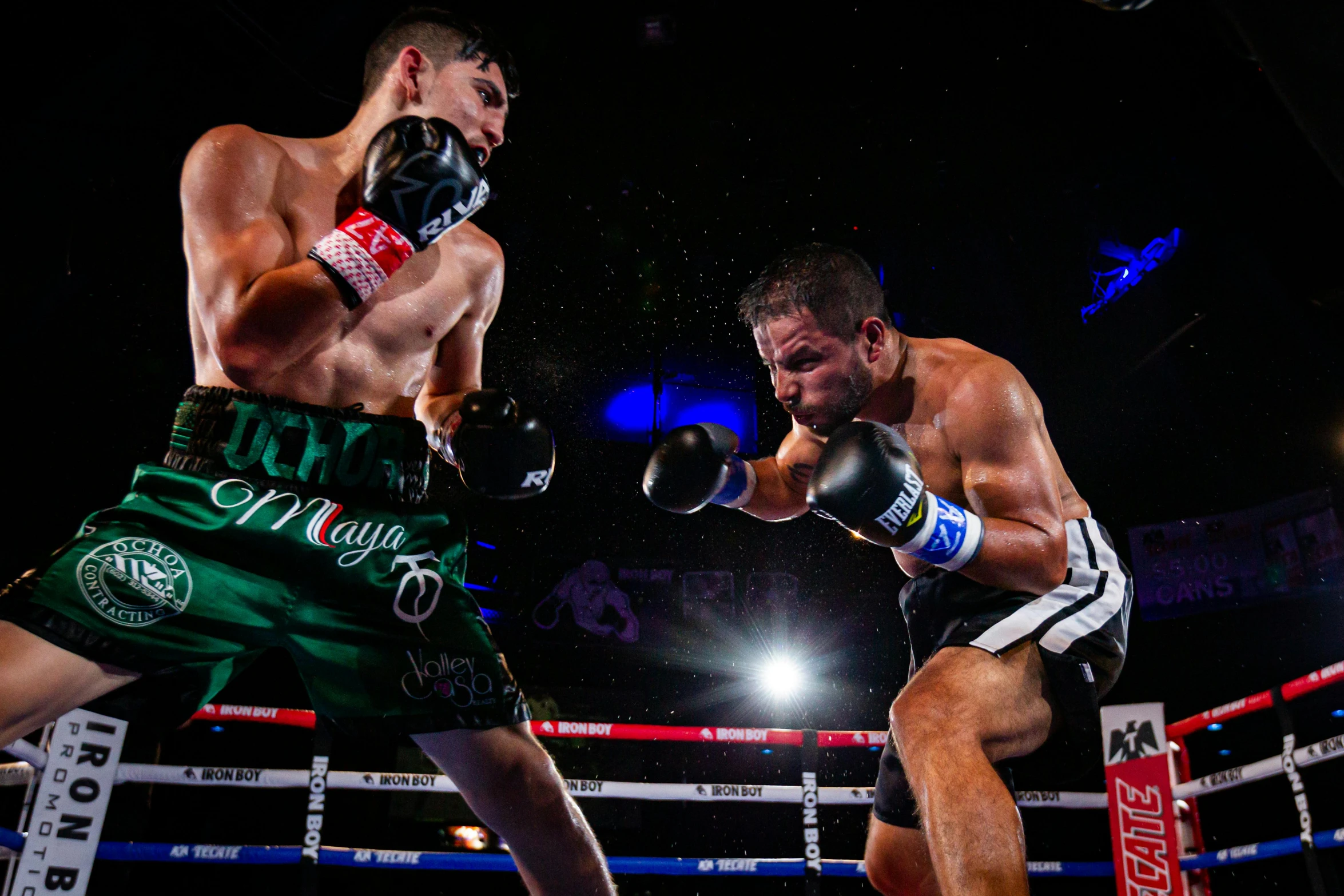 two boxers standing in the middle of a boxing ring