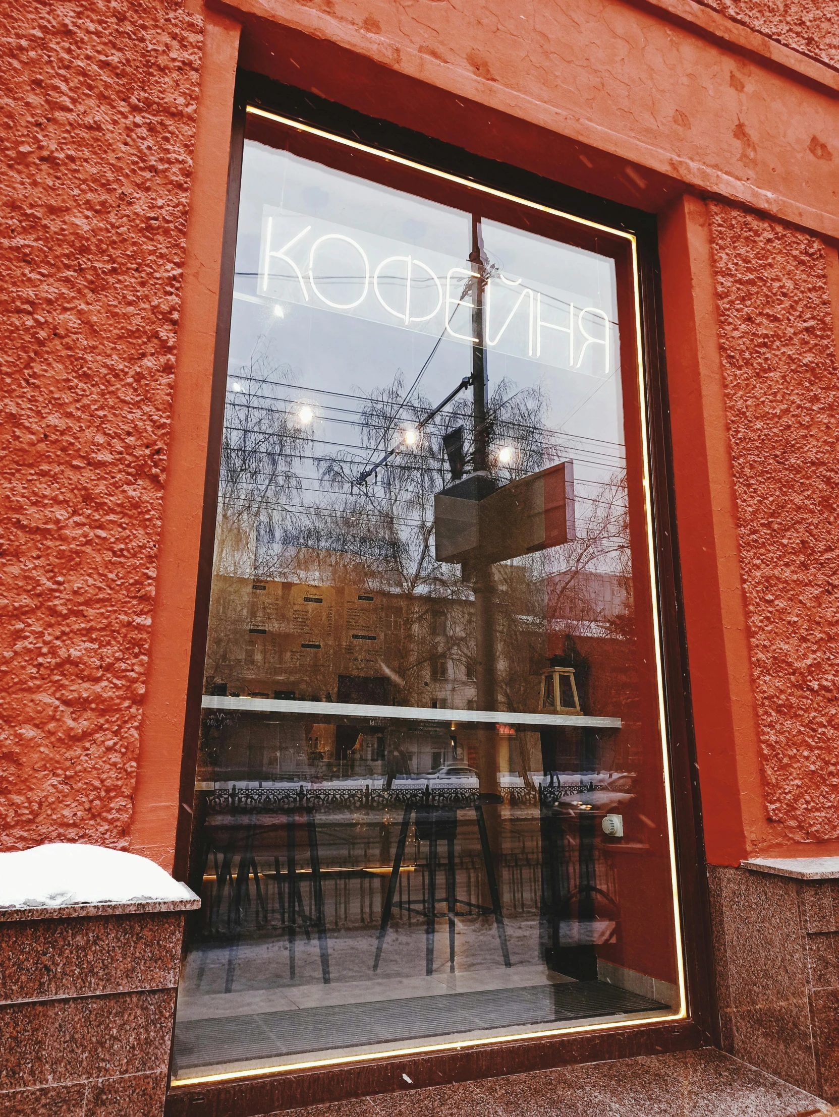 the storefront of a city restaurant that has been recently painted in orange and red