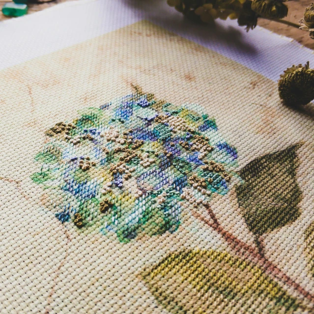 needle work being worked on an embroidered tablecloth