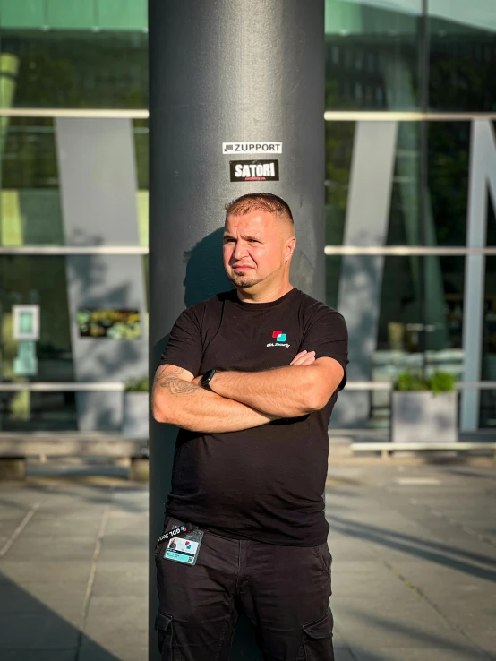 a man poses with his arms crossed as if waiting