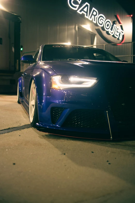 a very pretty blue car in front of a building