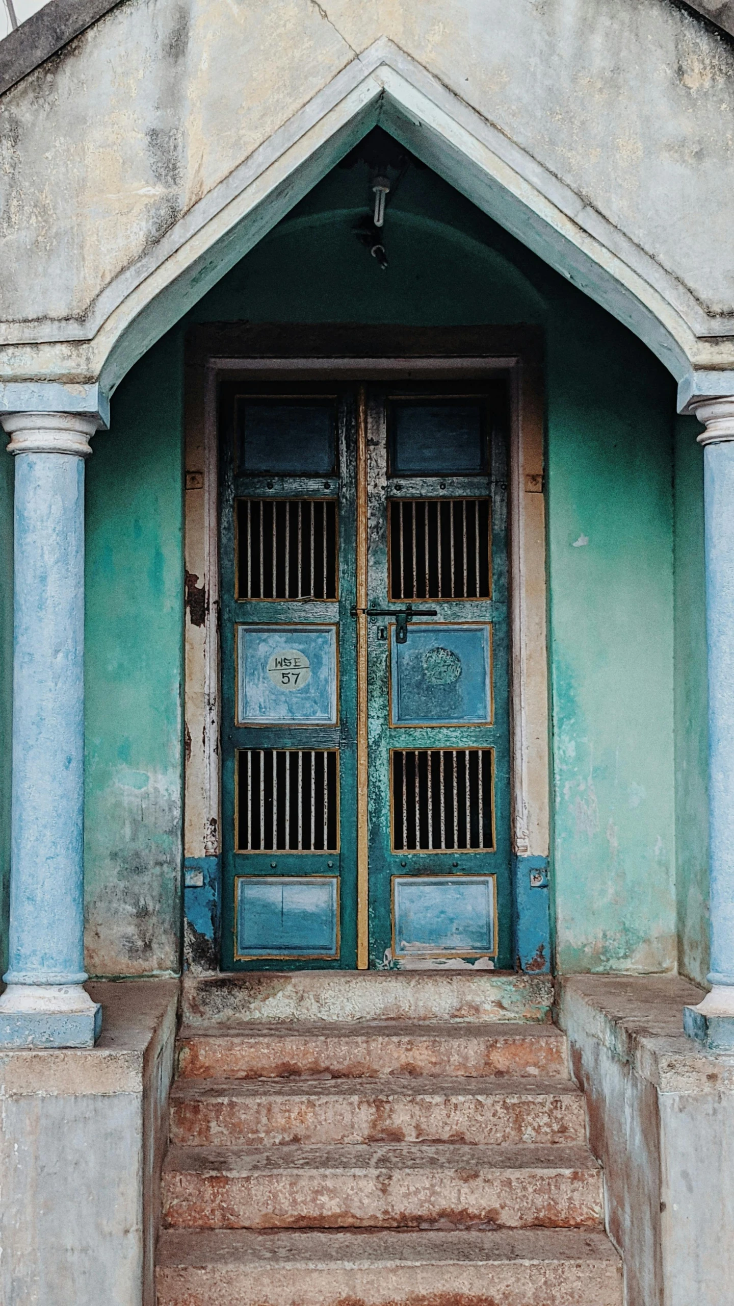 an old building with two large blue doors