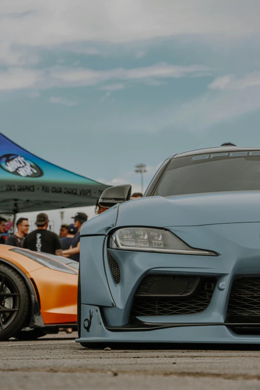 people standing next to cars and airplanes