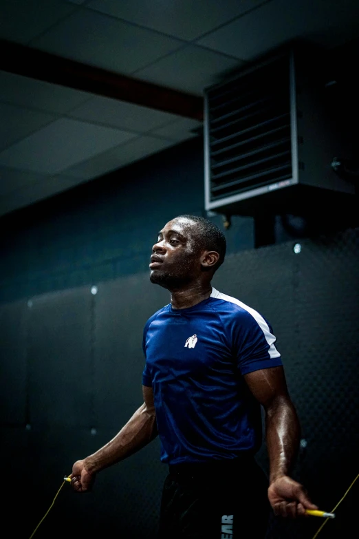 an african american male in a blue shirt is holding a yellow rope