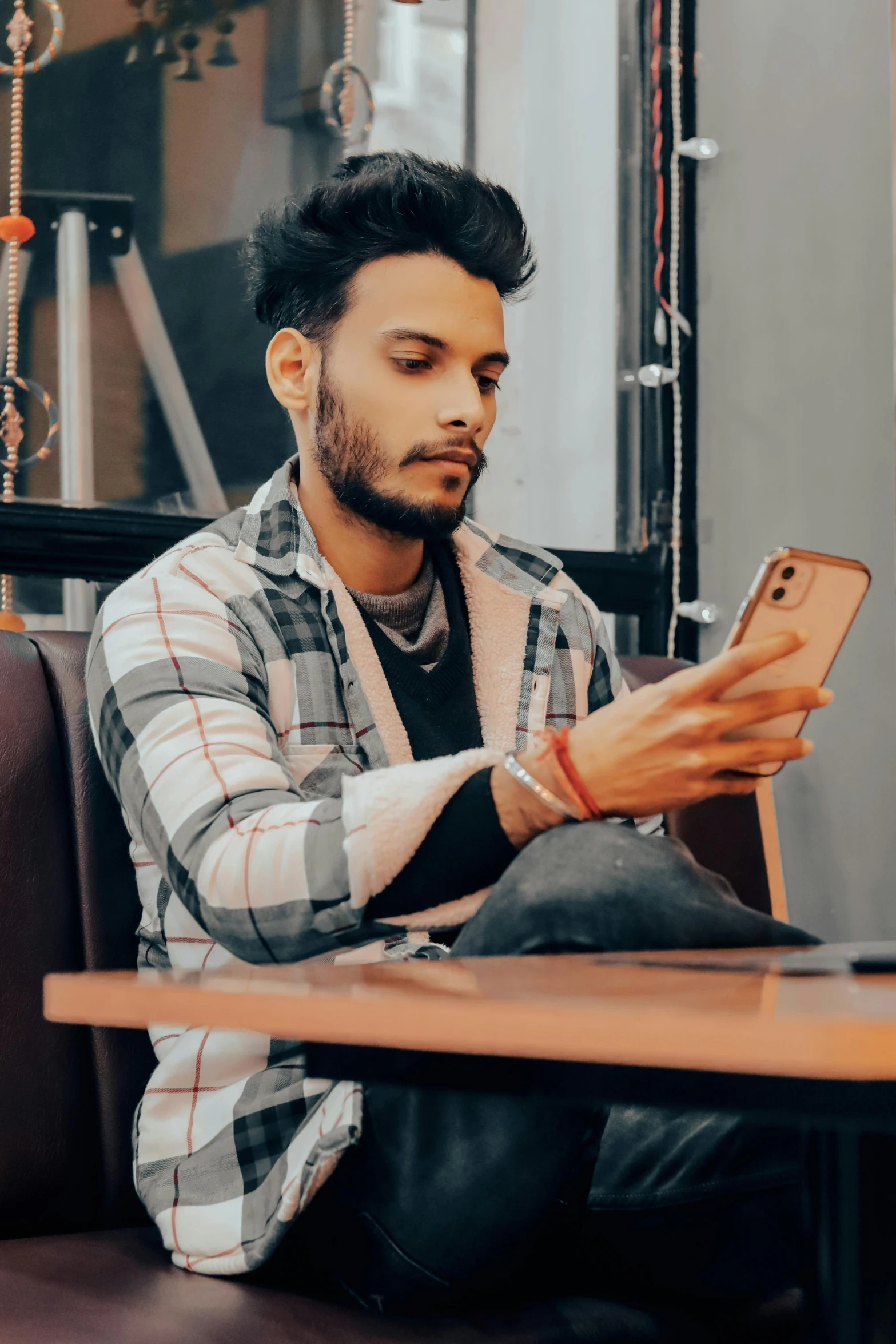 a man holding a phone and sitting at a table