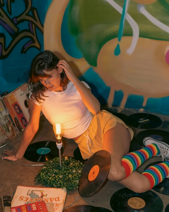 a woman sitting in front of a record player next to a candle