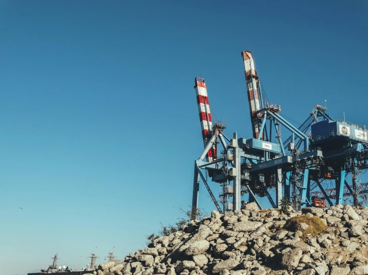 cranes are being constructed in the middle of a rocky area