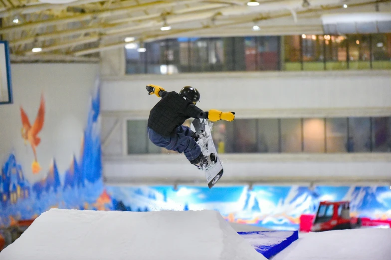 a snowboarder performs a high jump at the skate park