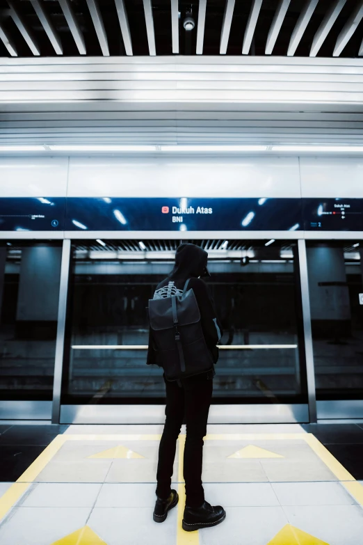 a person with a backpack standing on the platform