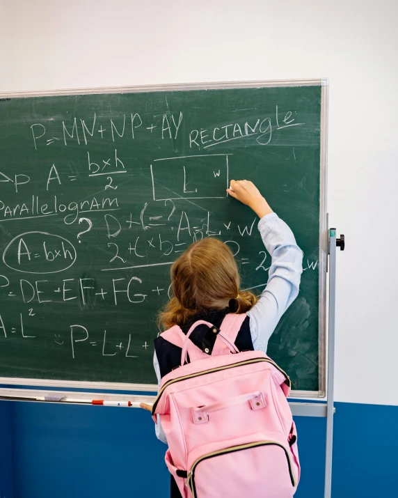 an up close picture of someone writing on the blackboard