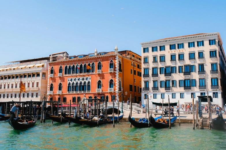 two buildings along the waters with gondolas in front of them