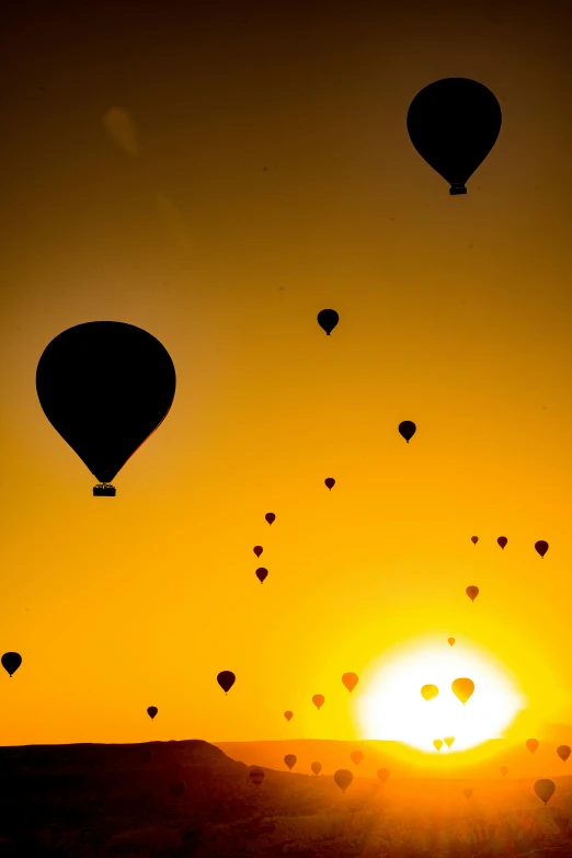 a sunset s of balloons flying in the sky