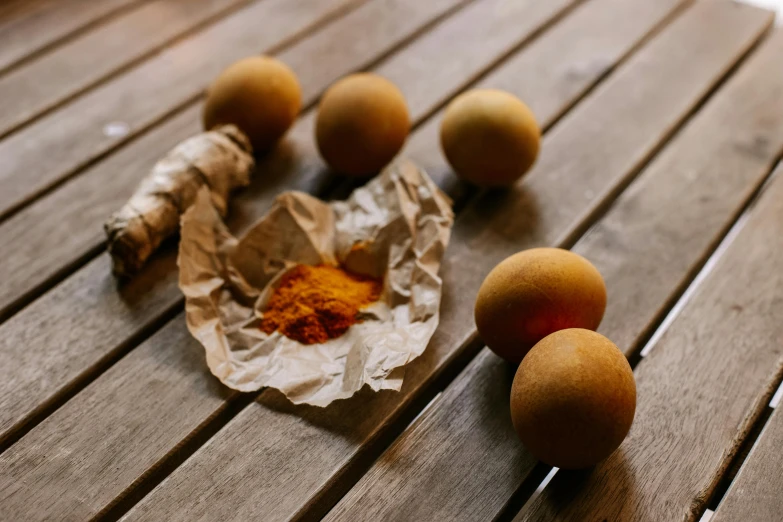 some food sitting on a table with paper and wood