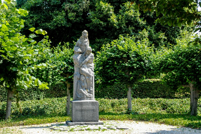 a large statue sitting on top of a cement block in a park