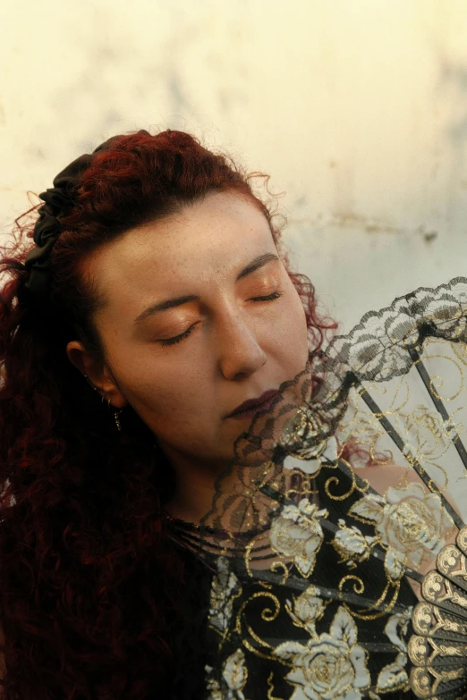 a woman with long hair and red curly hair holding an umbrella