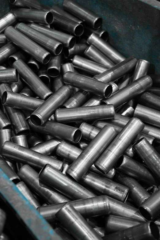 an assortment of steel pipes in a bin