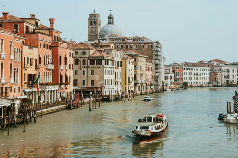 a very long boat on the river between buildings