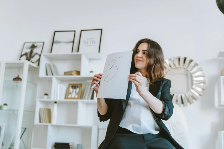 a woman looking at her notebook while sitting in a room