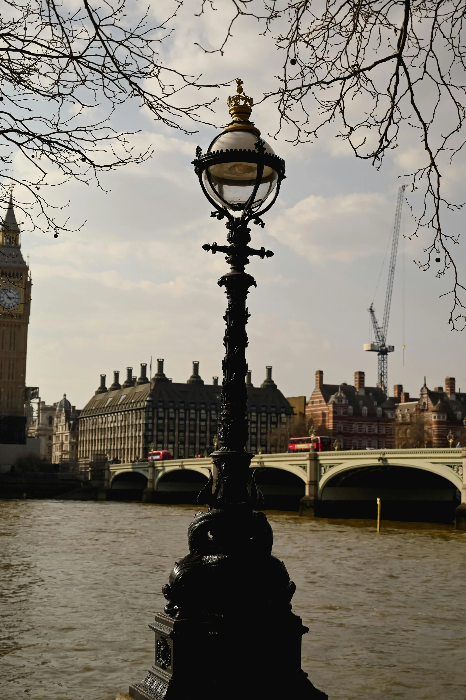 an old lamp post next to a river in london