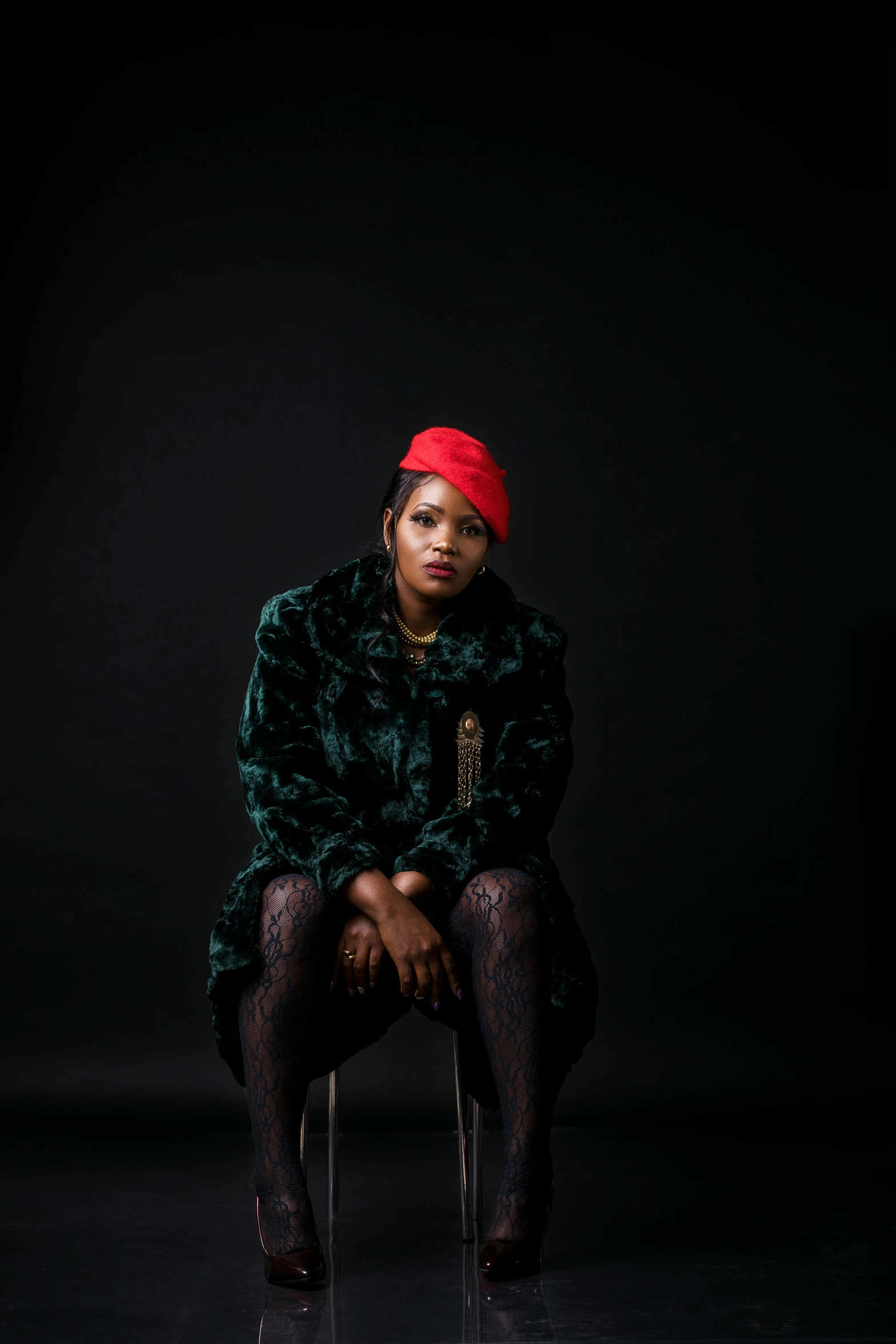 a woman in a long green coat sitting down