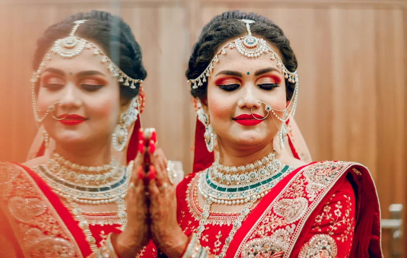 two women dressed in indian clothing appliqued to each other