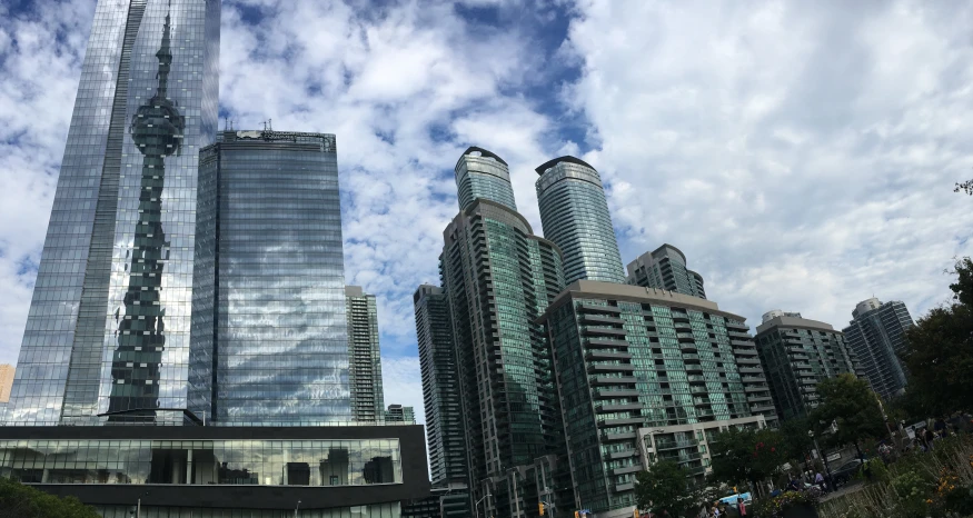 two very tall buildings with many people walking through them