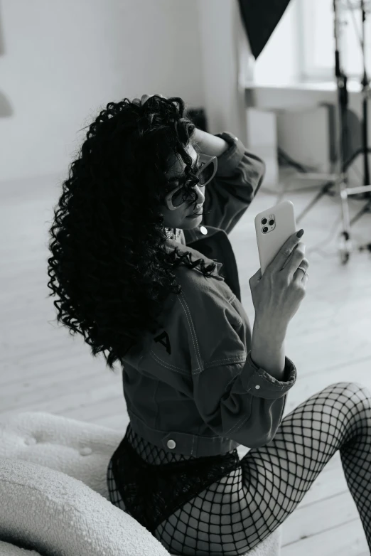 a woman sitting on top of a white couch holding a cell phone