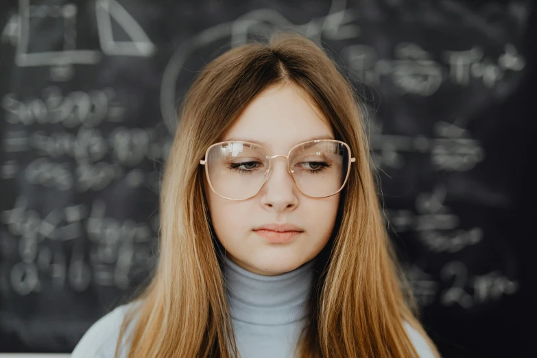 the woman wearing glasses is staring at her cell phone