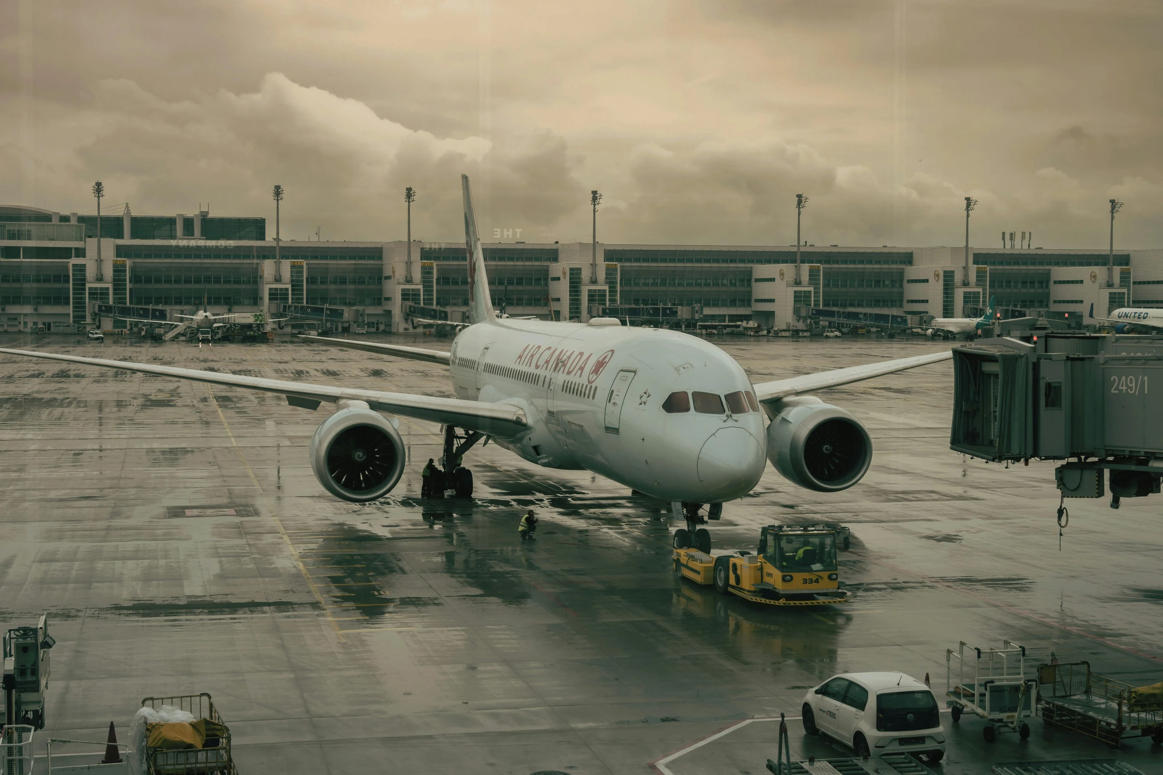 large white plane in runway with cargo area in background