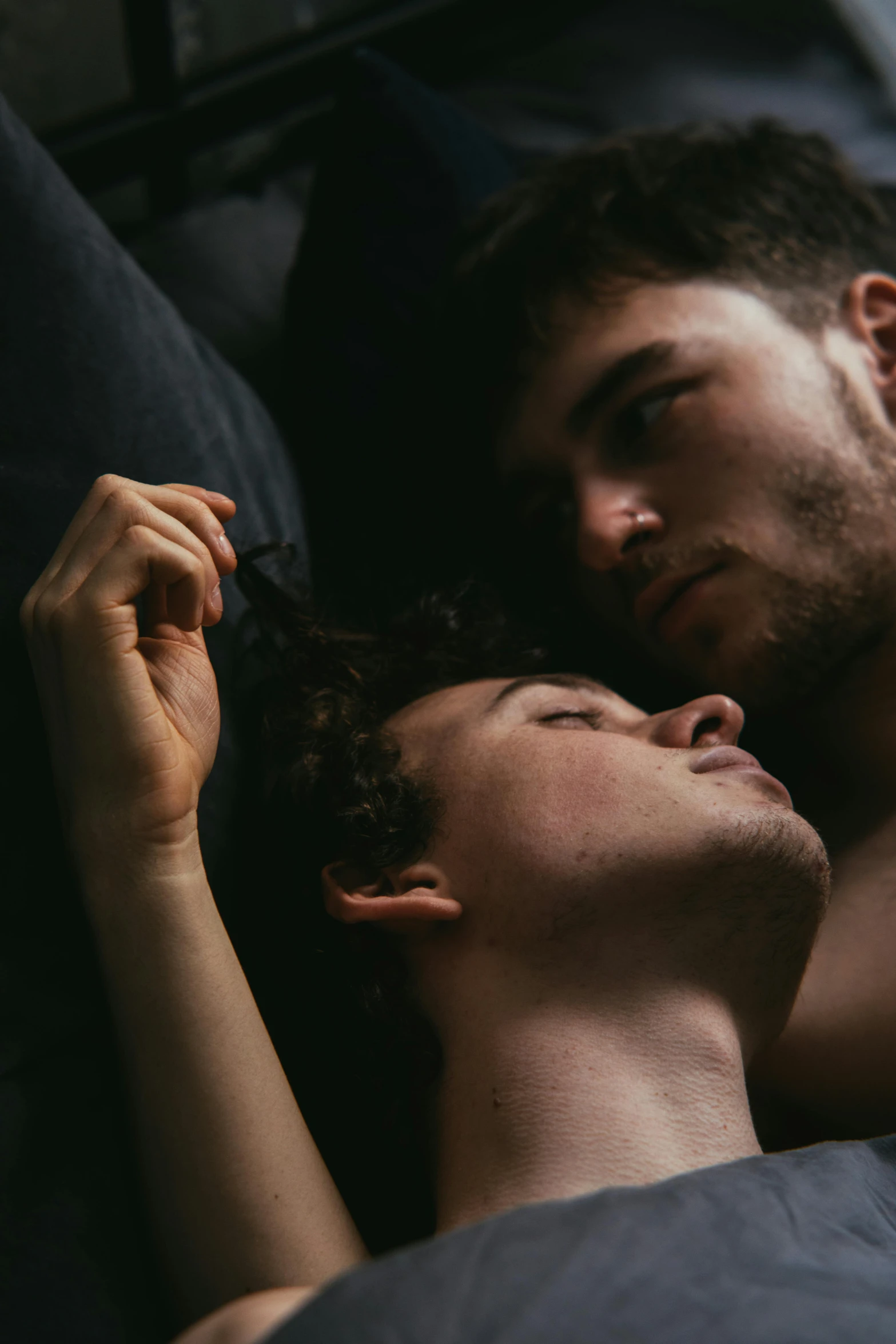 two people laying in bed sleeping together