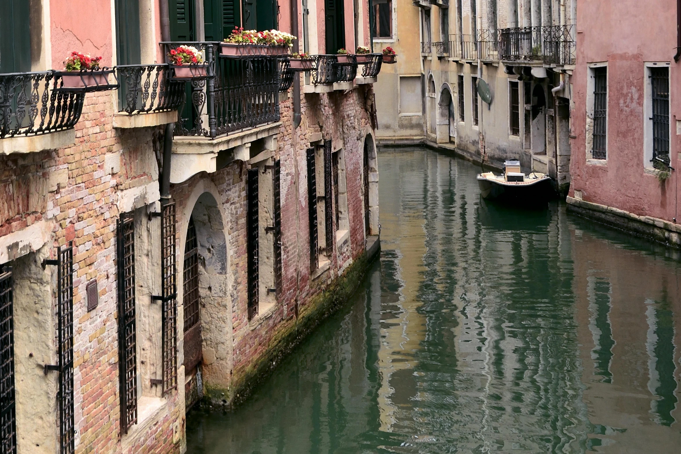 some buildings a boat and some water and one is green