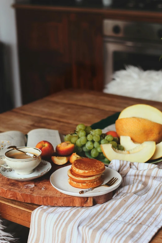 a breakfast table with coffee, fruit and sandwiches