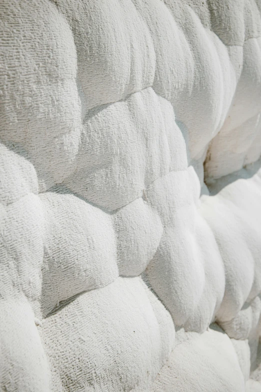 close up of a bed in white with ruffled edges