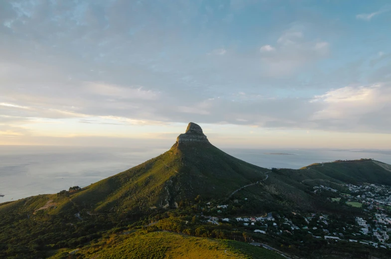 mountain with blue sky and ocean in background