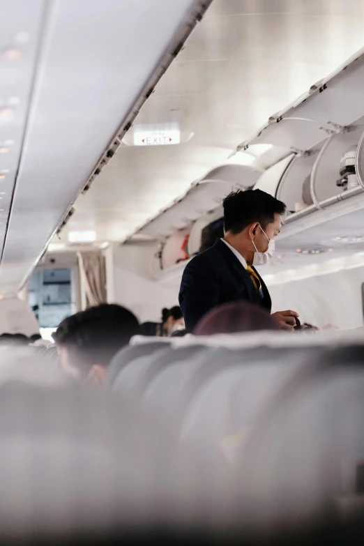 a man standing on a plane with headphones around his neck