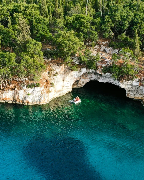 a boat on clear water in front of an opening