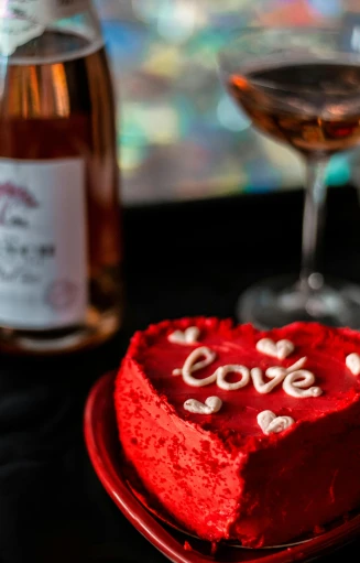 a heart shaped cake and wine on a table