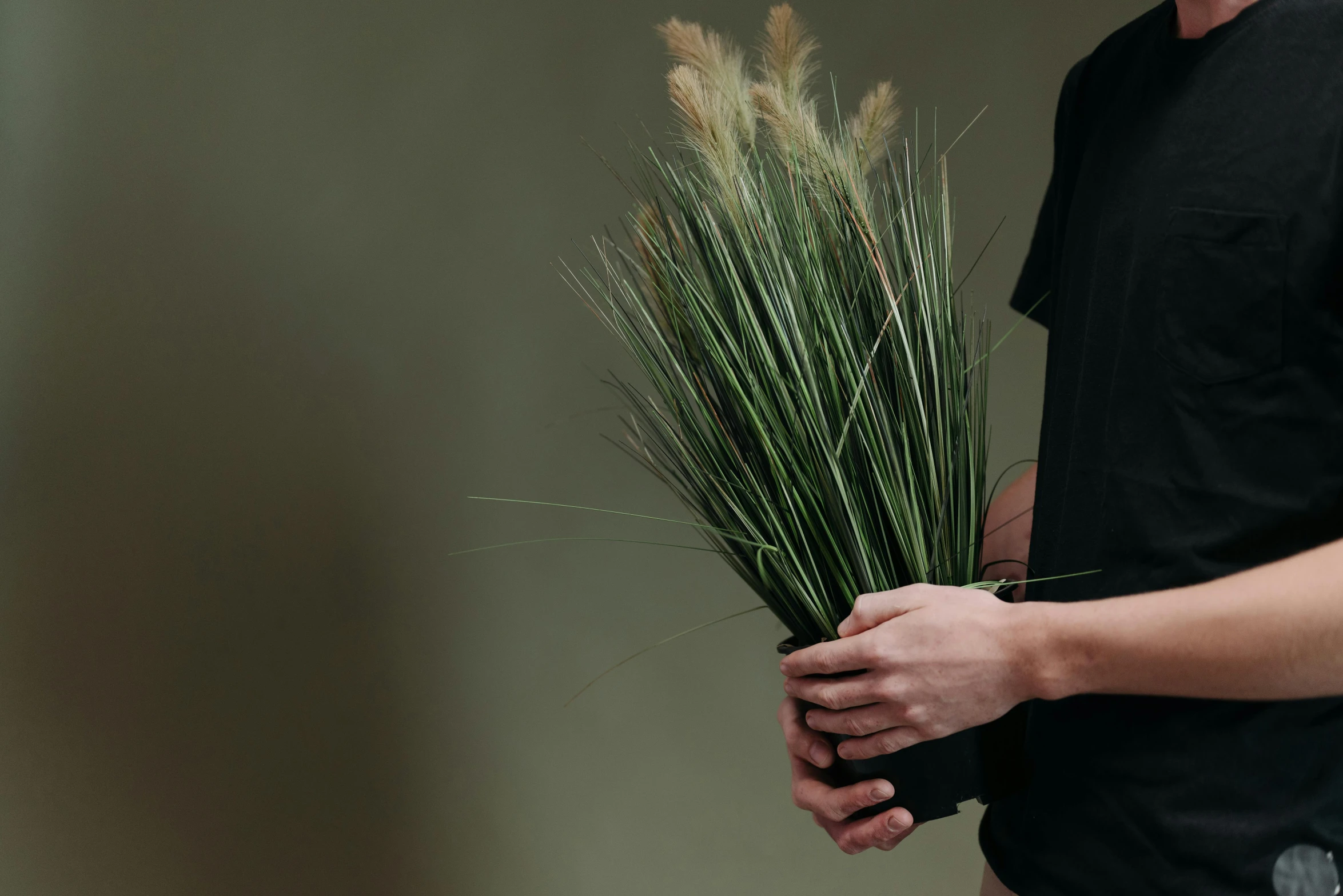 a person holds some grass in front of their face