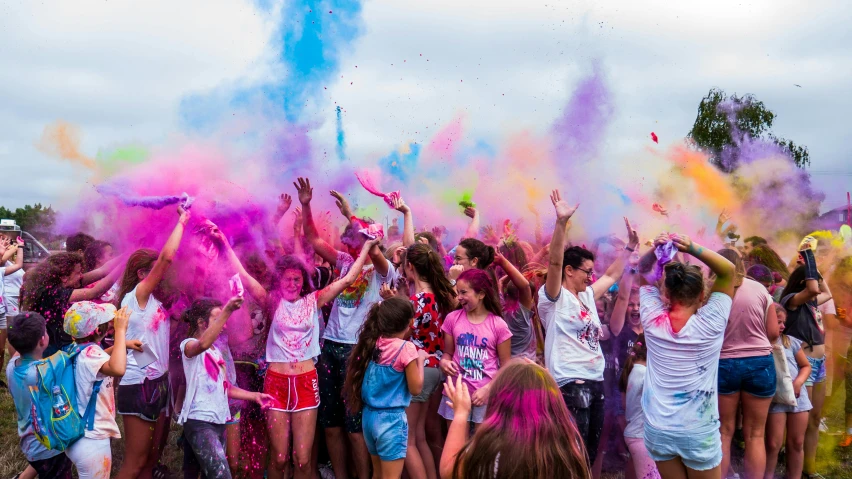 a group of people in colored powder are dancing