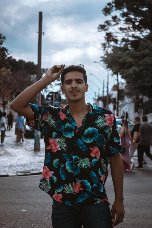 a man poses for the camera while wearing a flower shirt