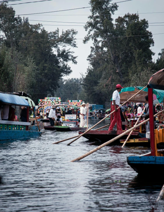 many canoes are floating through the water near shore