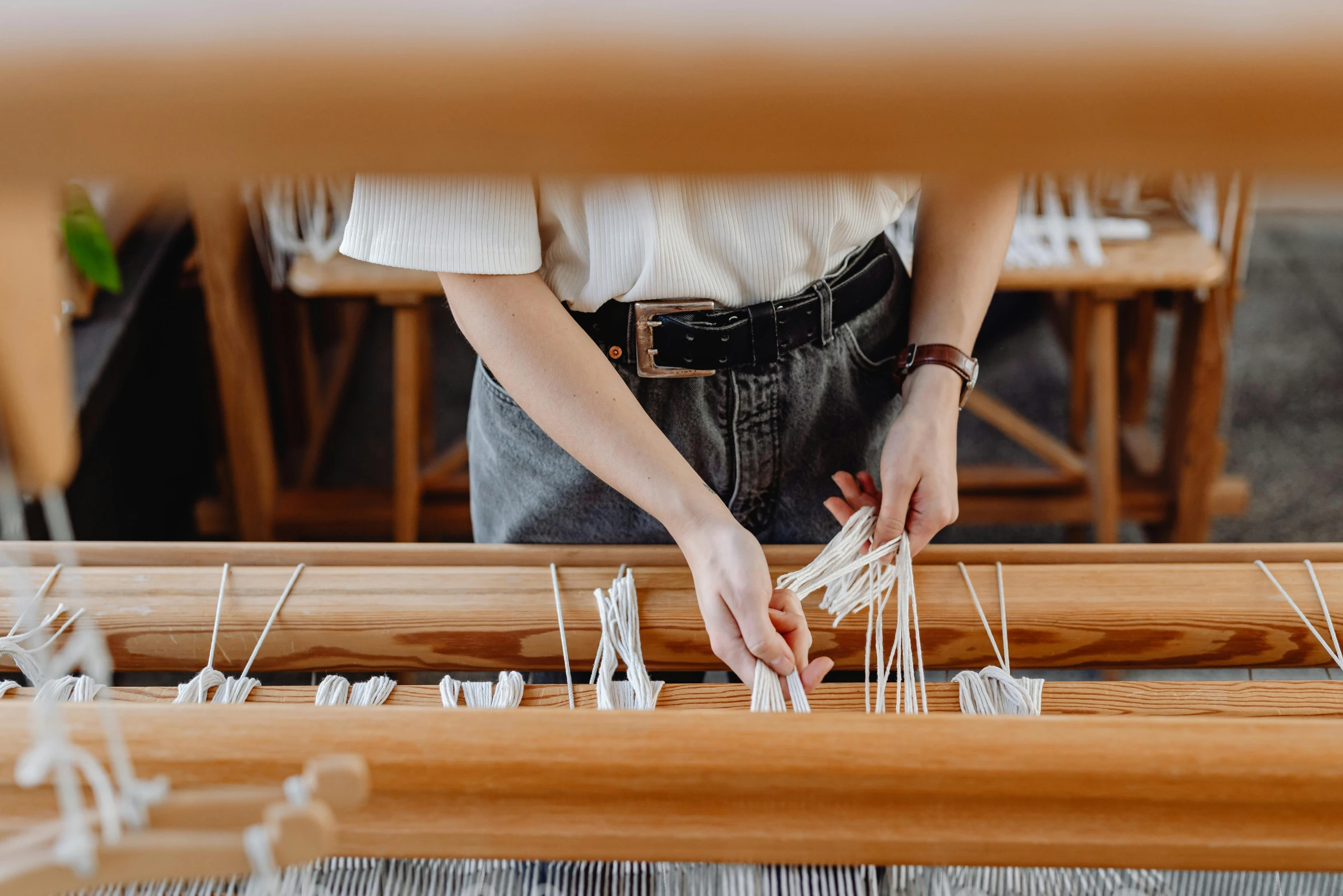 a woman is weaving the cloth on the loom