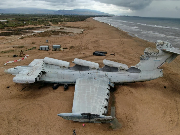 the large aircraft is on the beach near the water