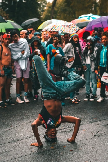 a man in shorts does a handstand as people watch from behind
