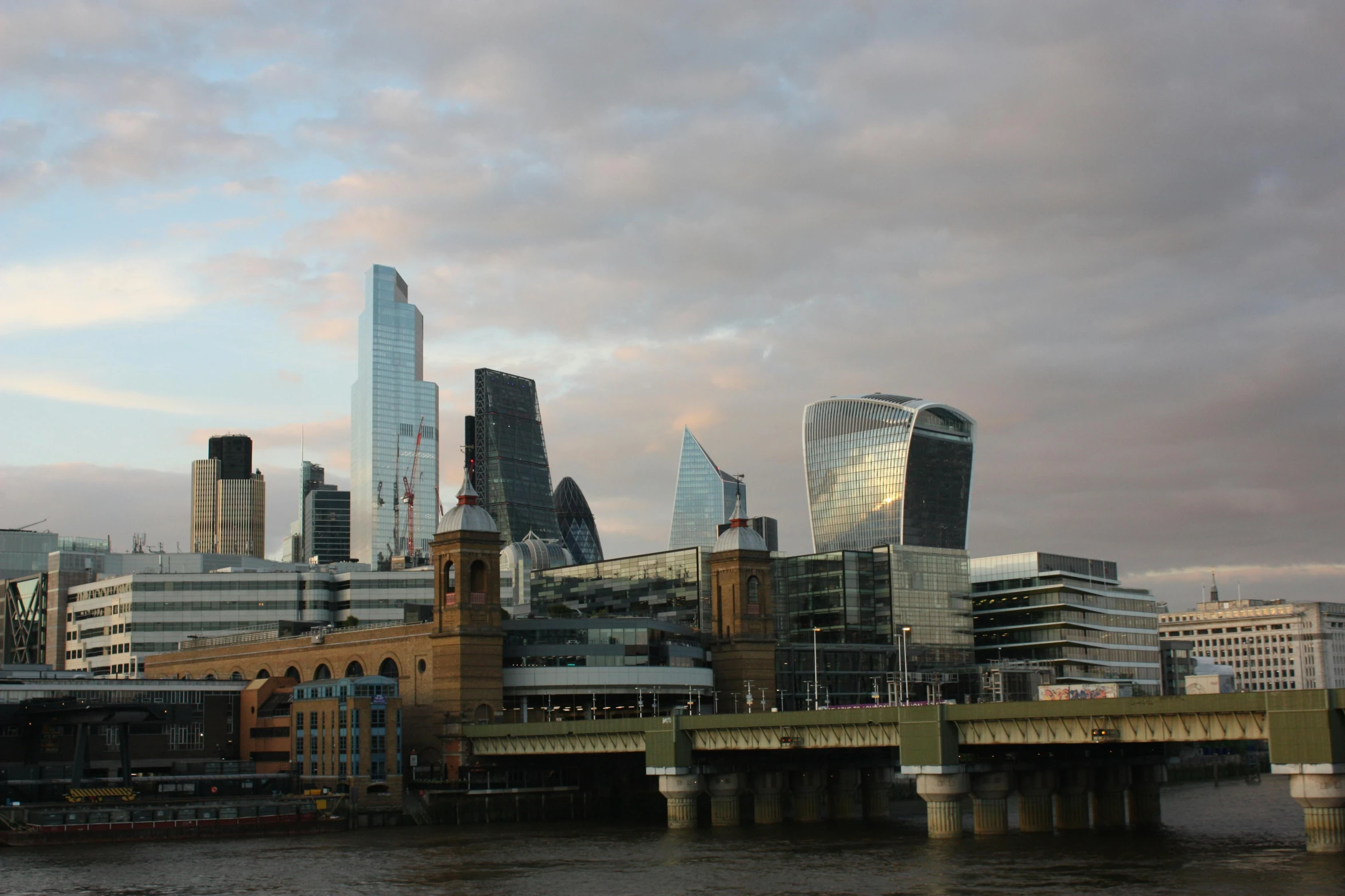 a river and bridge leading into some large city buildings