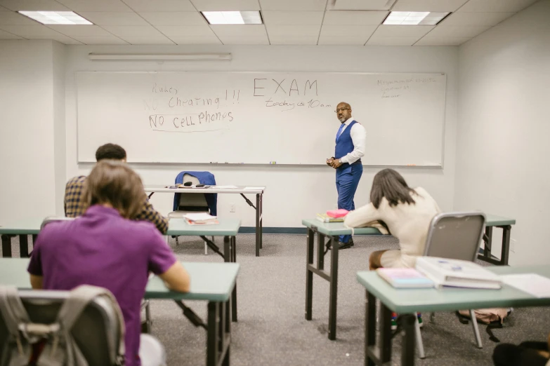 students sitting at desks in an empty classroom